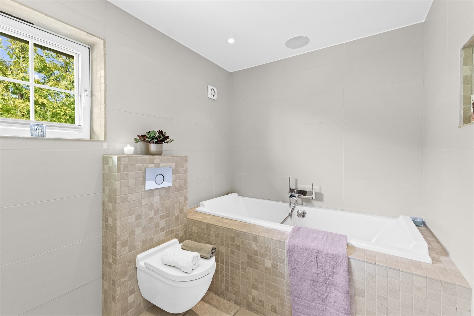 Badet har klosett og dusj i badekar. Galleribilde