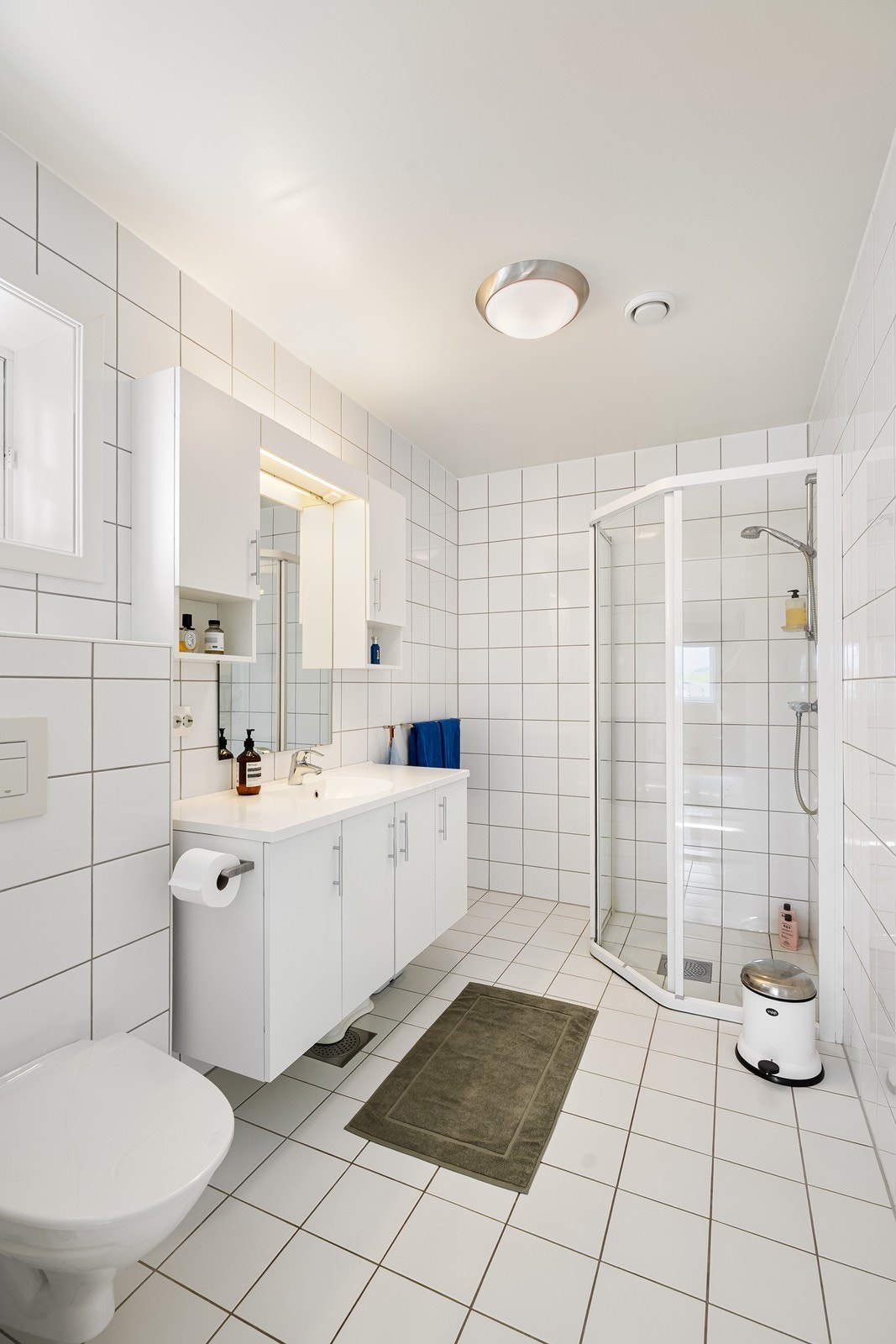 Badet inneholder dusjhjørne og vegghengt toalett, noe som gir et rent og funksjonelt uttrykk. Galleribilde