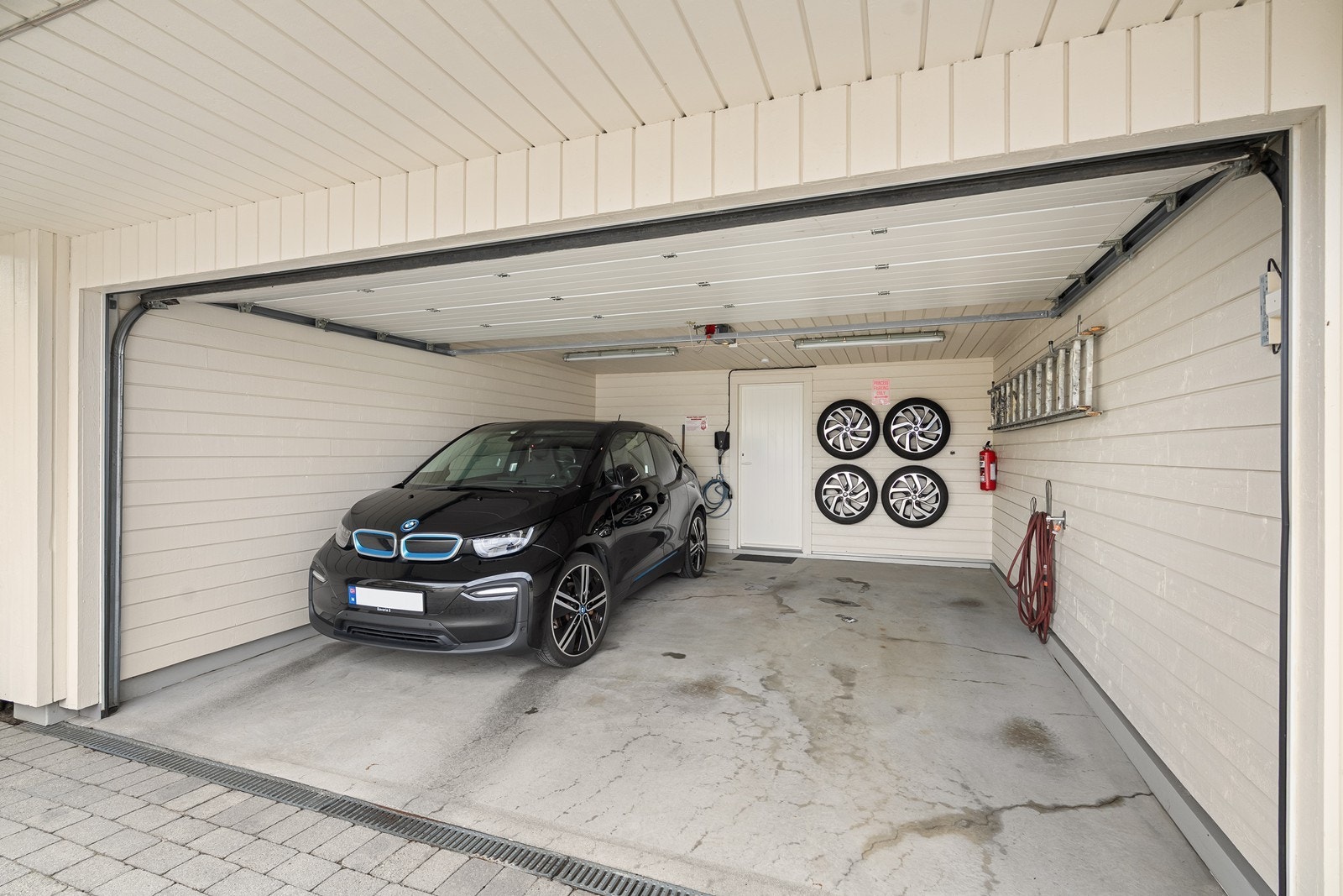 Dobbel garasje med bil-lader og god plass til parkering. I bakkant av garasjen er det inngang til bod, som gir praktisk ekstra lagringsplass. Galleribilde