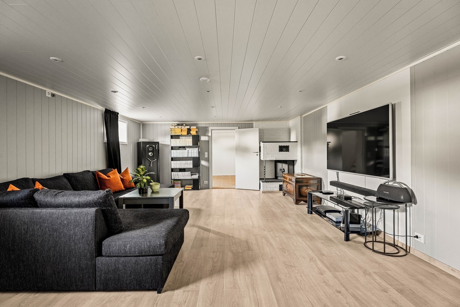 Overflatene i kjellerstuen består av laminatgulv, panelplater på veggene og panel i taket. Galleribilde