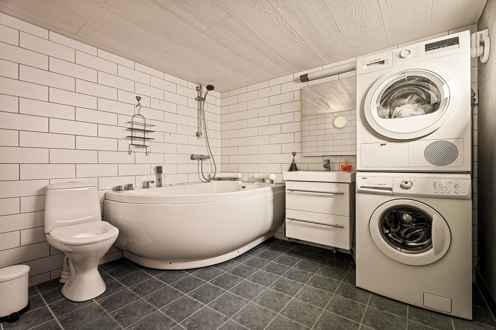 Badet i kjelleren ble pusset opp i 2015. Her er det badekar, elektriske varmekabler og opplegg for vaskemaskin. Galleribilde