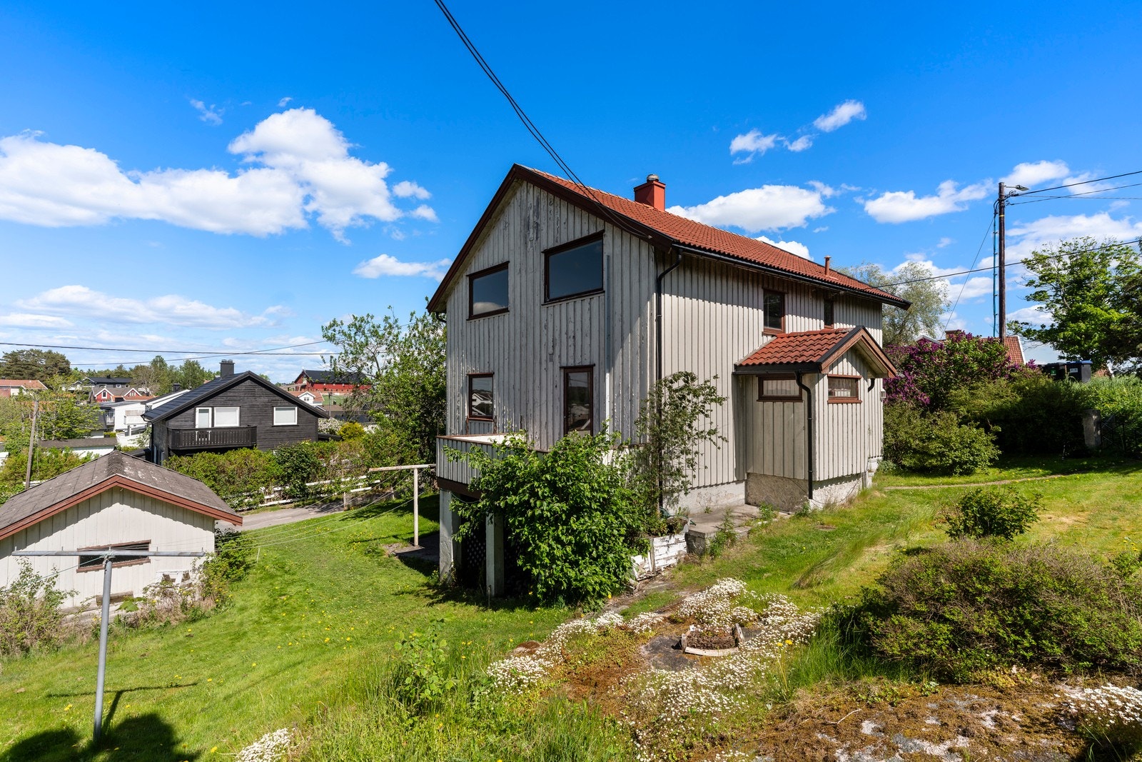 Terrassen har utsikt mot de grønne omgivelsene på tomten. Galleribilde