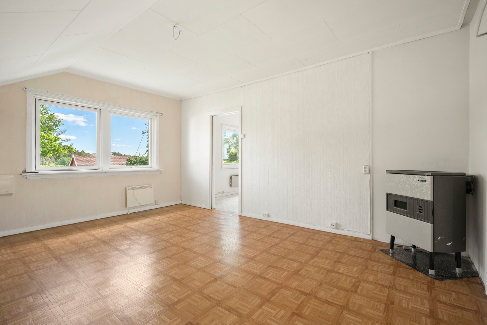 Stuen her har også en luft-til-luft varmepumpe fra 2017 og en peisovn som oppvarmingskilde. Galleribilde
