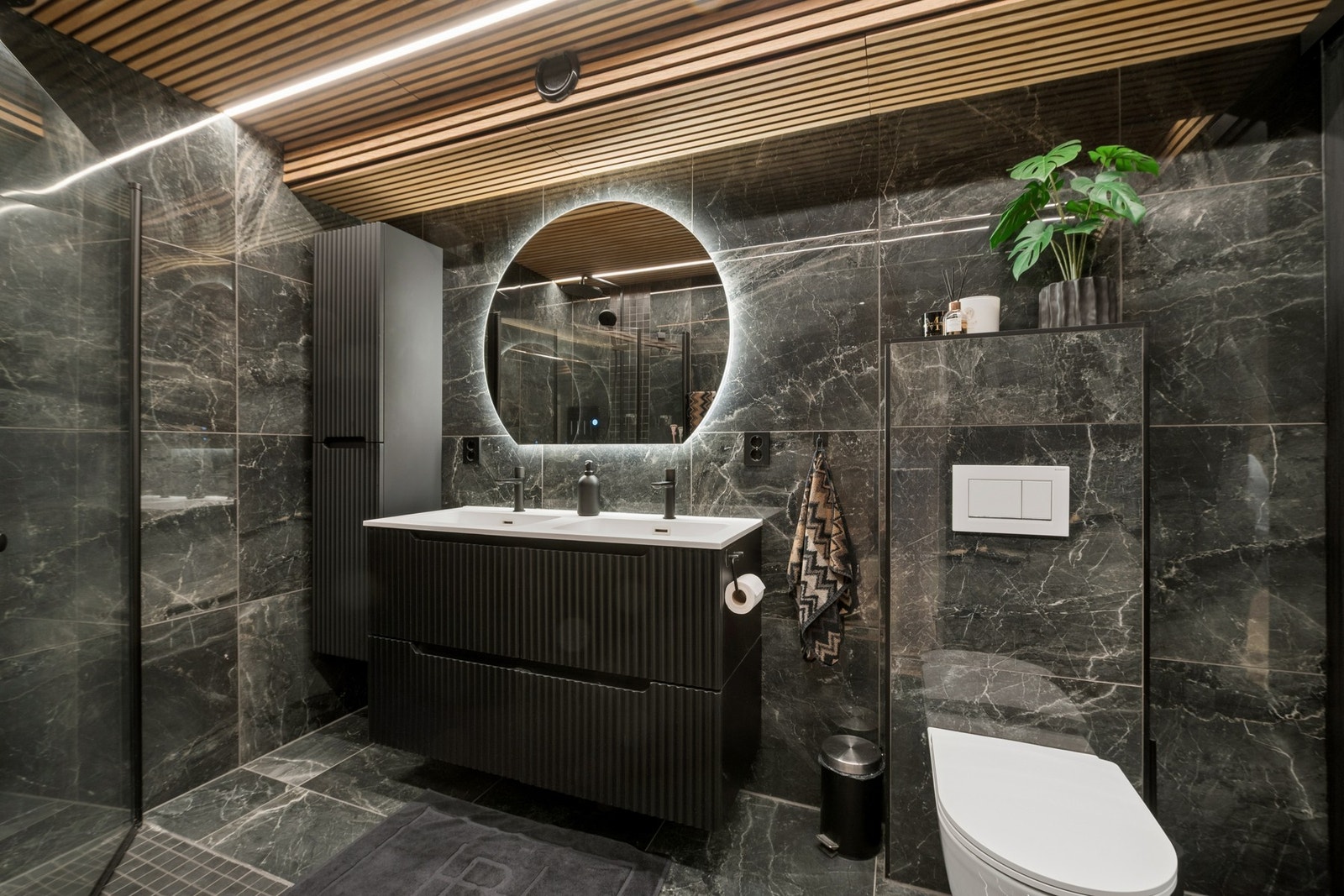 Badet fra 2024 fremstår med høy standard, spilertak, dobbel servant og vegghengt toalett. Galleribilde