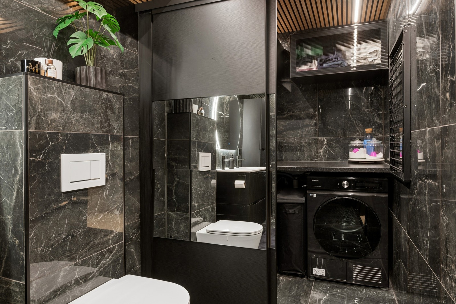 Badet har også plass til vaskemaskin og tørketrommel, praktisk gjemt bak skyvedør med speil. Galleribilde