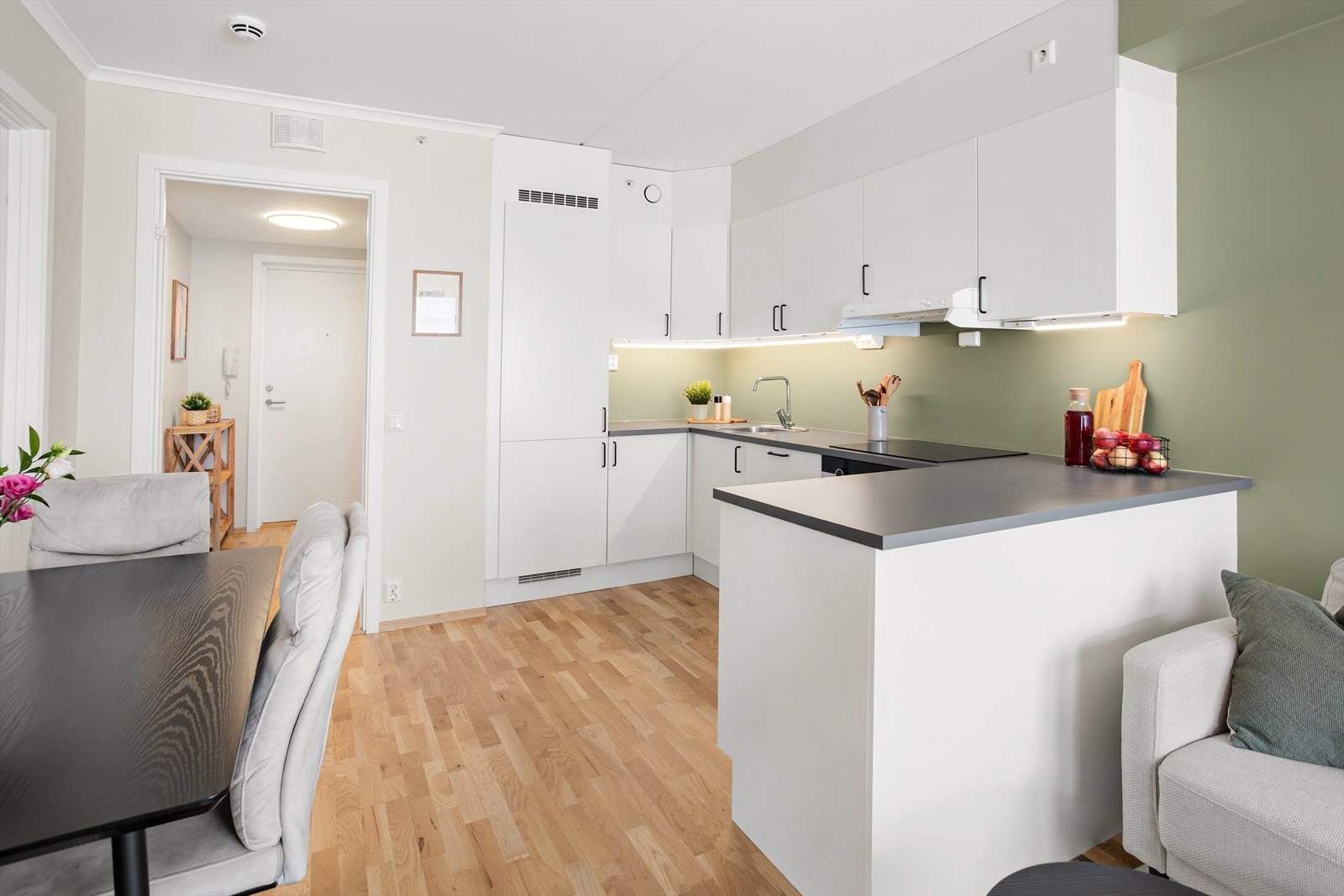 Stilren kjøkkeninnredning med glatte fronter og en slitesterk benkeplate i laminat. Galleribilde