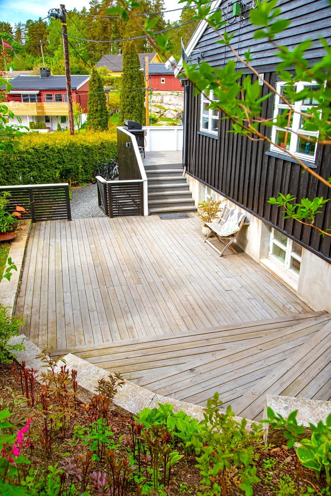 Gruset stikkvei fører til sydvendt terrasse. Herfra er det trapp til vestvendt veranda ved stuen og til terrasse ved inngangsparti mot øst. Galleribilde