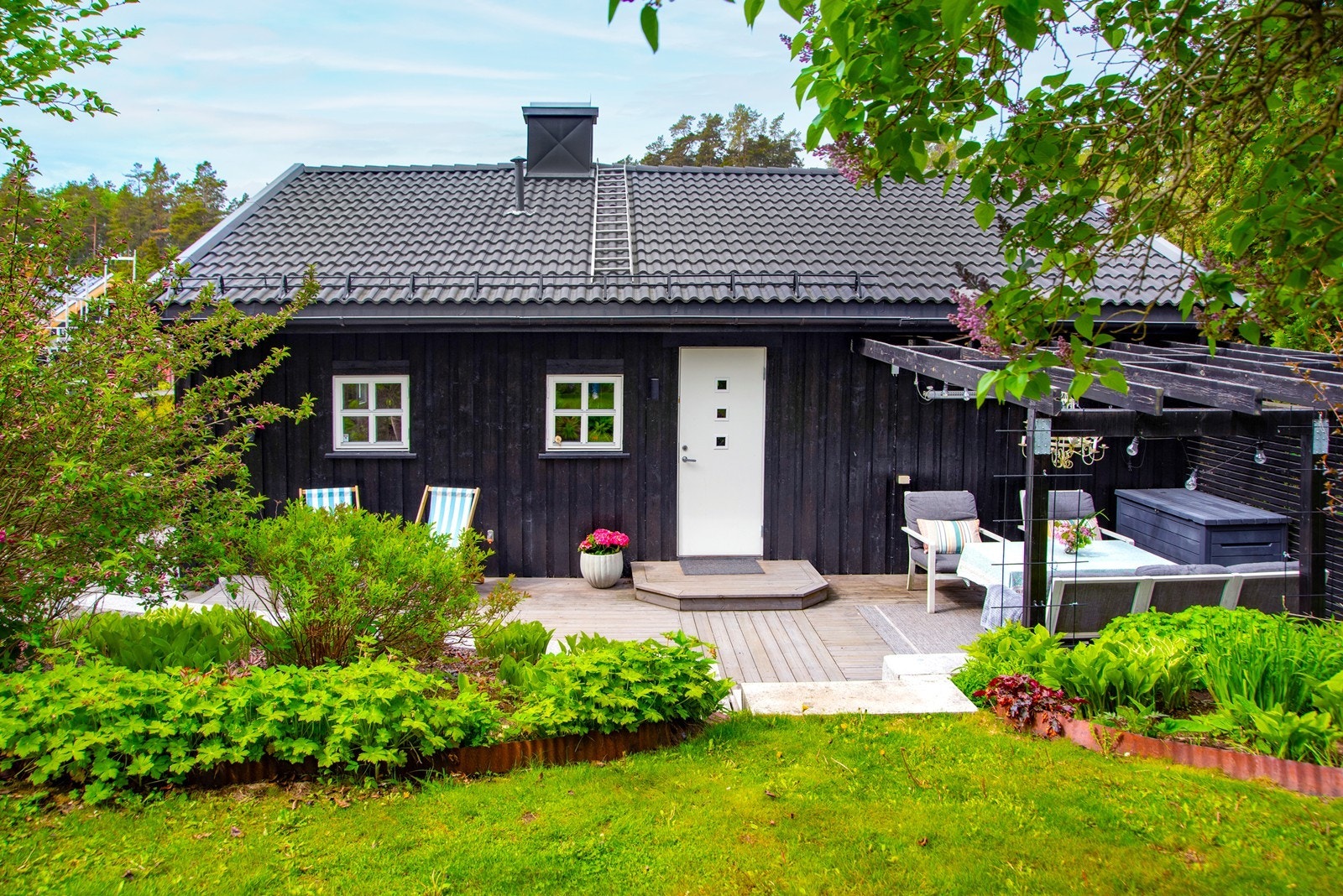 Inngangspartiet ligger skjermet på baksiden av huset. Her er hyggelig pergola og trapp i granitt til hage. Galleribilde