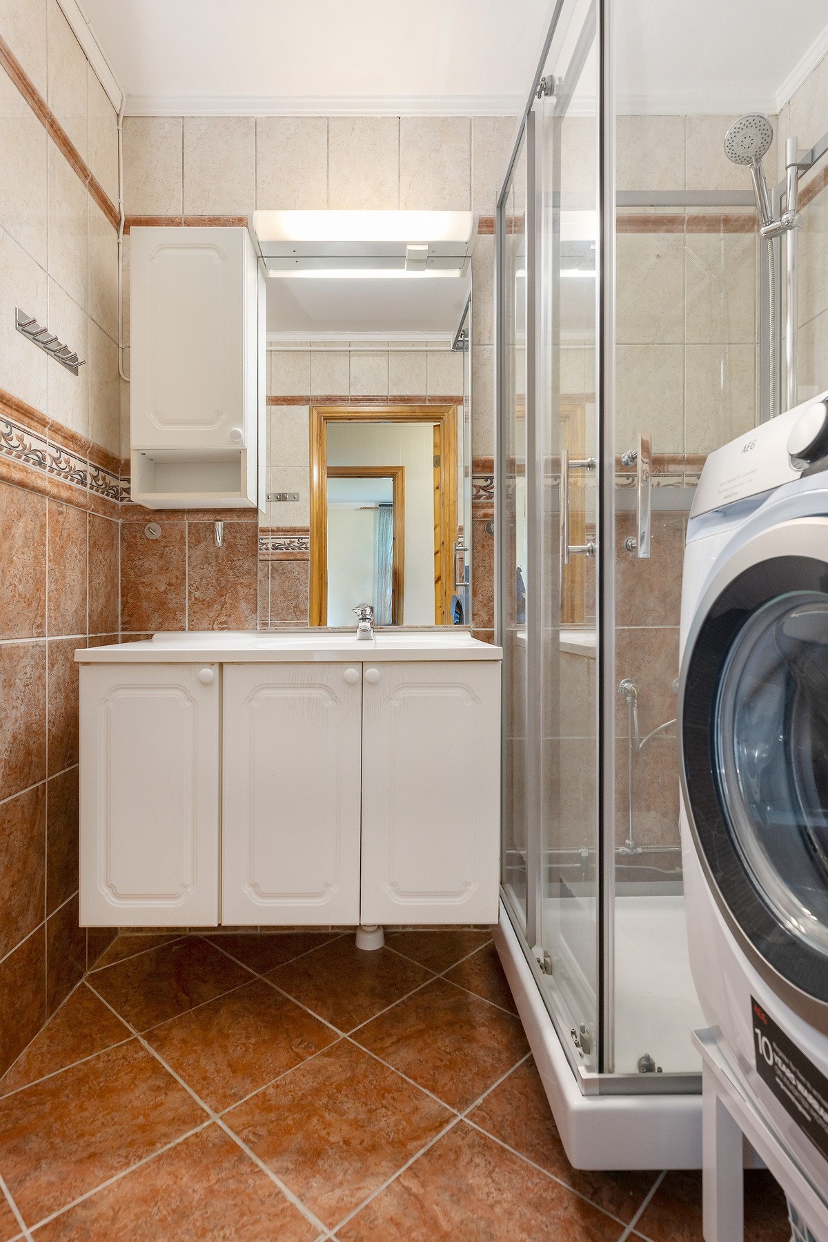 Badet er flislagt og har en praktisk planløsning som dekker dagens behov. Rommet har en funksjonell utforming med dusjløsning og standard sanitærutstyr. Galleribilde