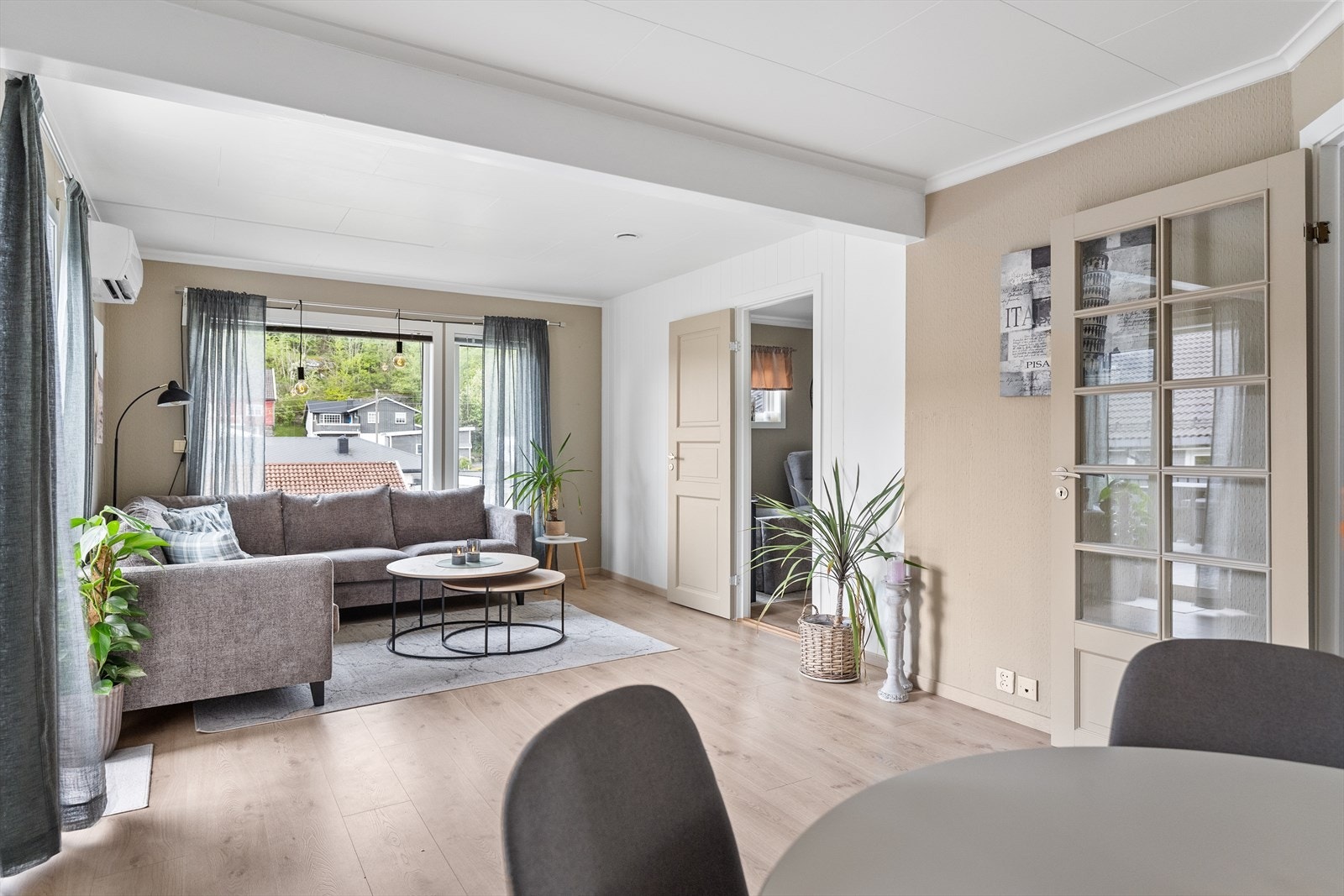Stuen har laminatgulv og malte overflater i tidsriktige fargetoner som gir rommet et moderne og innbydende uttrykk. Fra stuen er det adkomst til et separat TV-rom/soverom. Galleribilde
