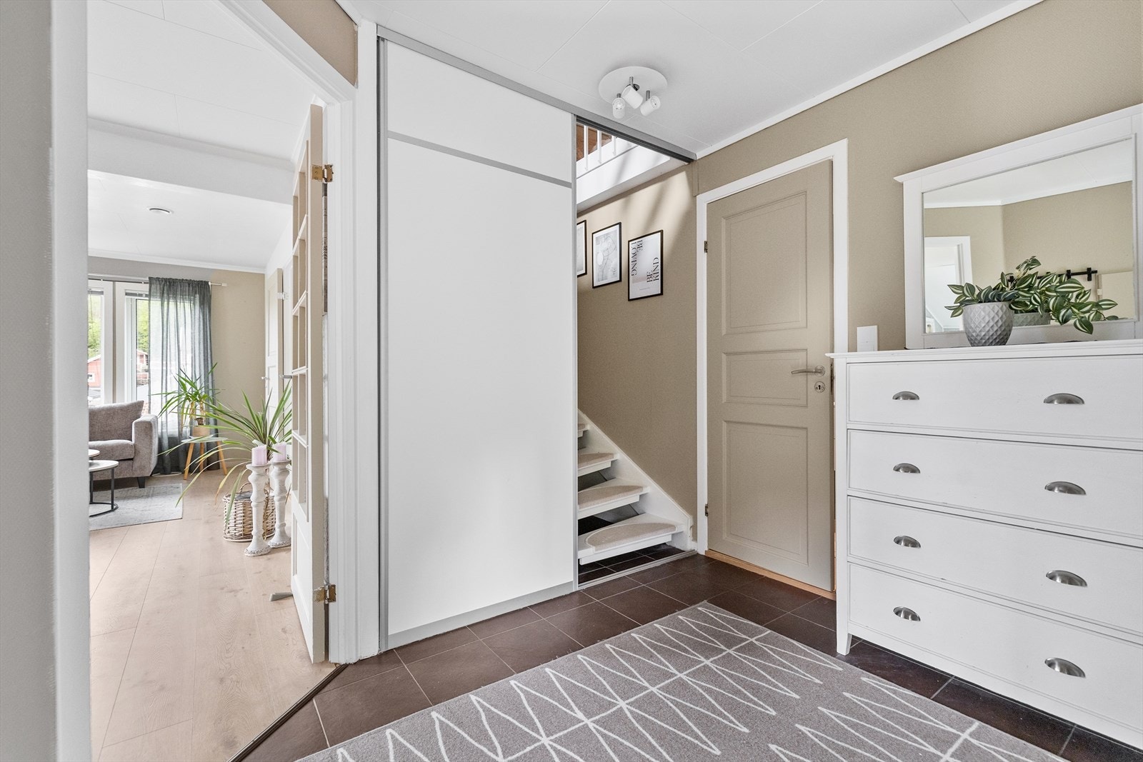 Fra entréen leder en malt tretrapp med sklisikre trinn opp til leilighetens innredede loft. Galleribilde
