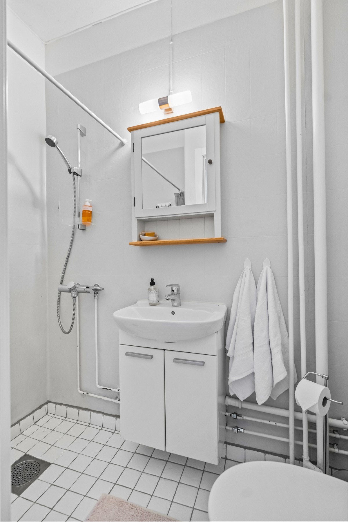 Badet har en funksjonell utforming med flislagt gulv, samt våtromstapet/belegg og malte overflater på veggene, malt tak. Galleribilde