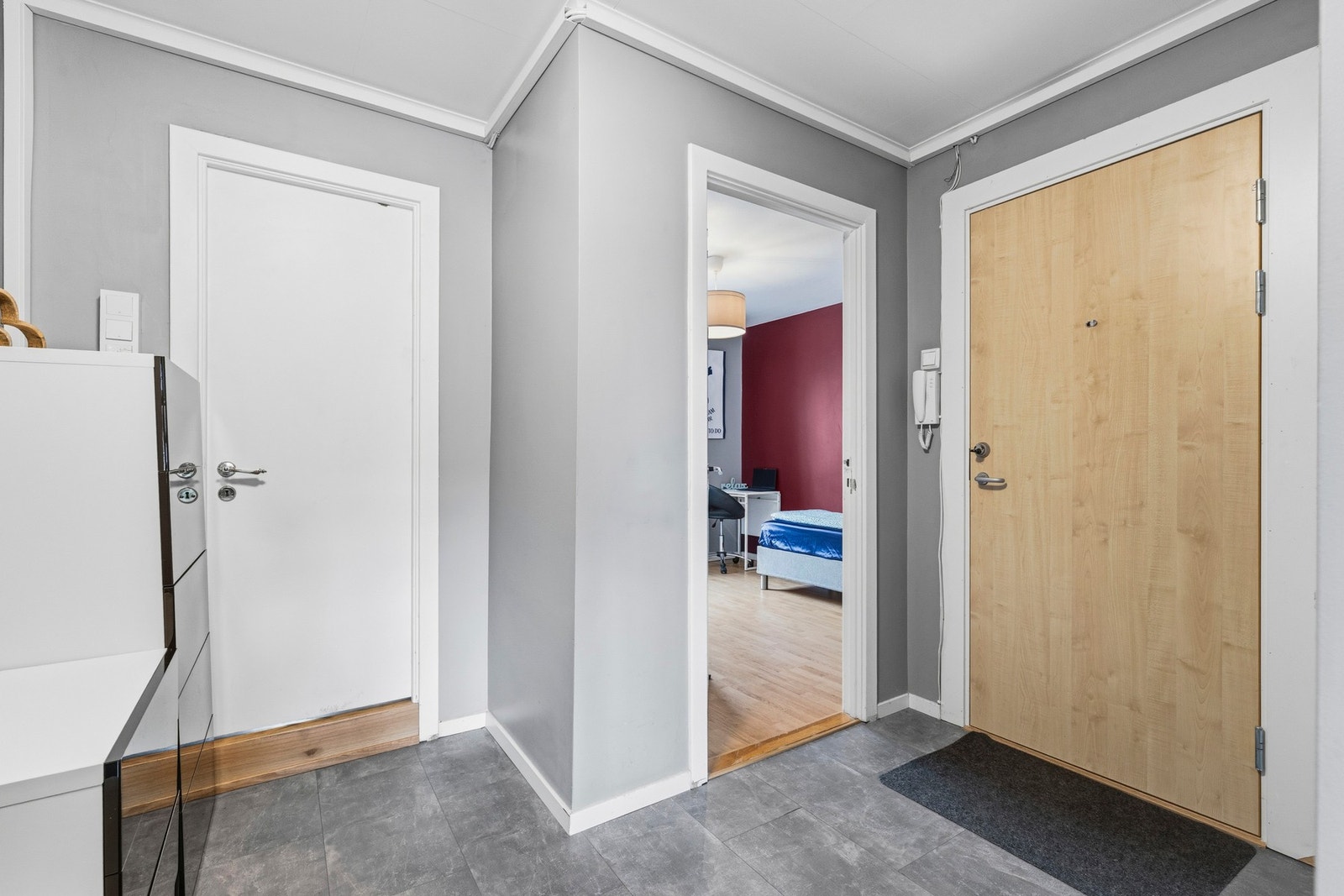 Gang med romslig utforming som gir plass til knaggrekker på vegg, sittebenk til av og påkledning og kommode. Galleribilde