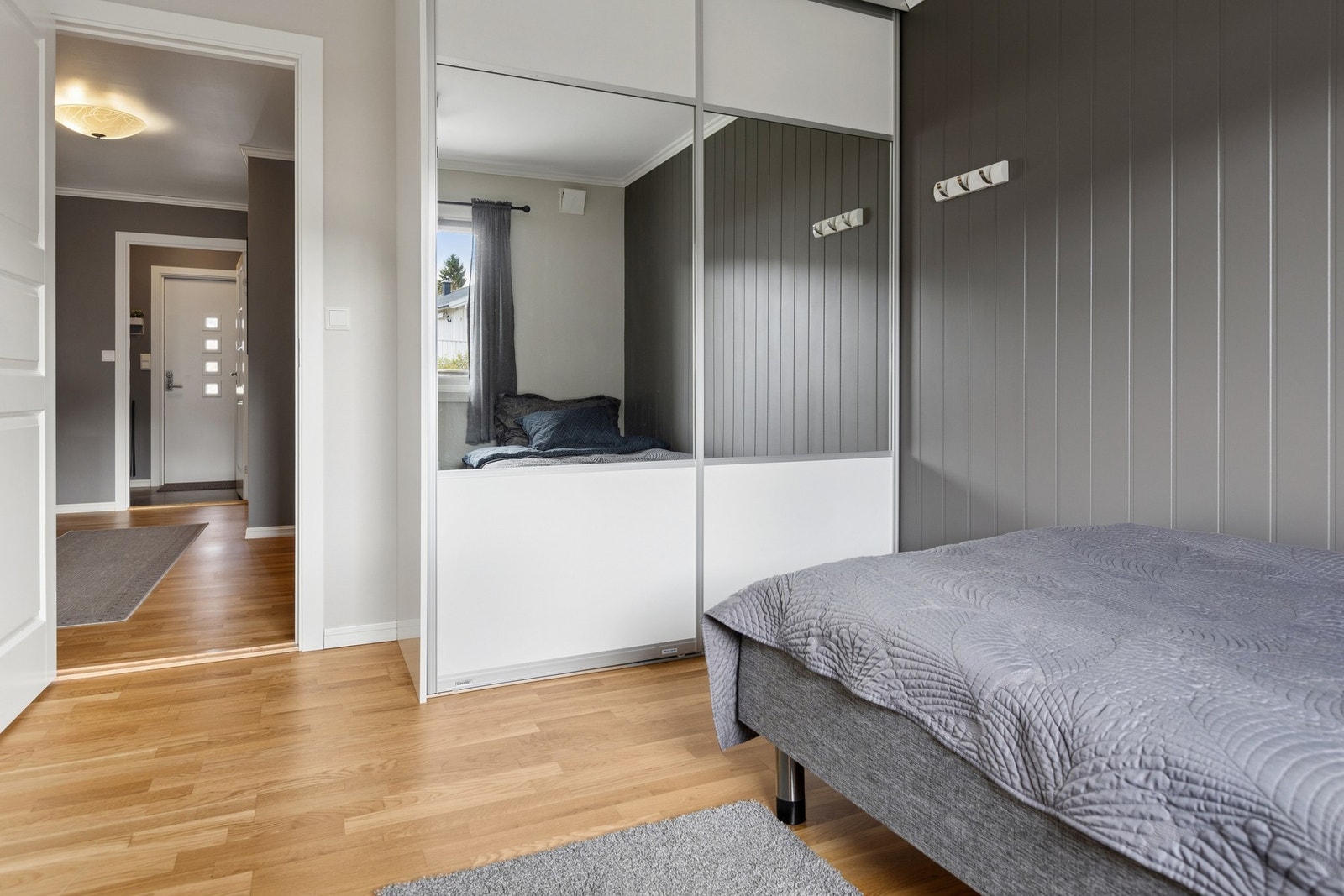 En romslig skyvedørsgarderobe med speilfronter gir effektiv oppbevaring Galleribilde