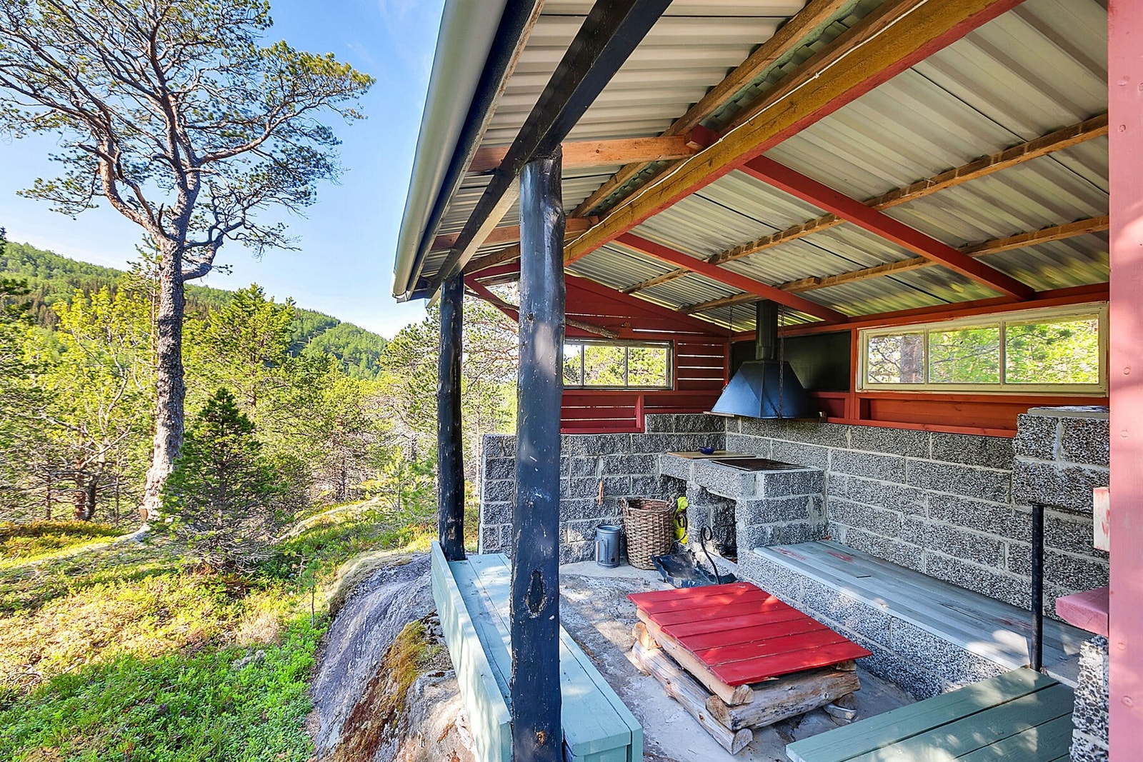 Inne i grillhuset er det murt ildsted og sittebenker under tak. Galleribilde