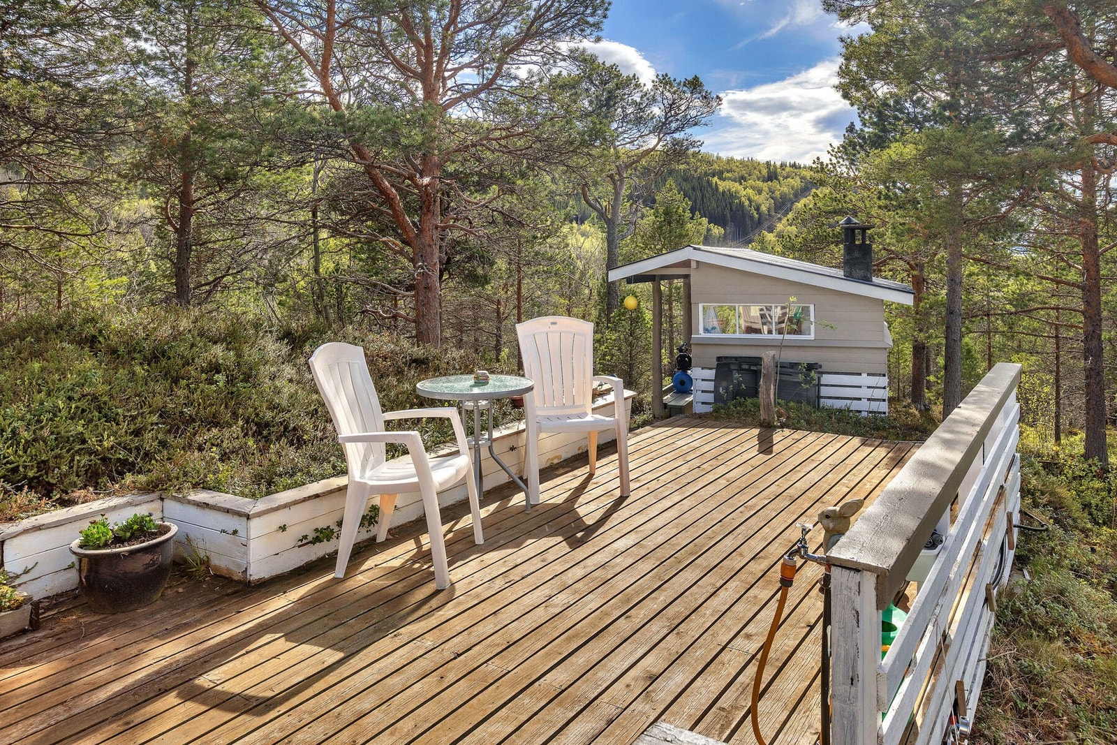 Fra terrassen er det utsikt mot grillhuset og skogen. Galleribilde