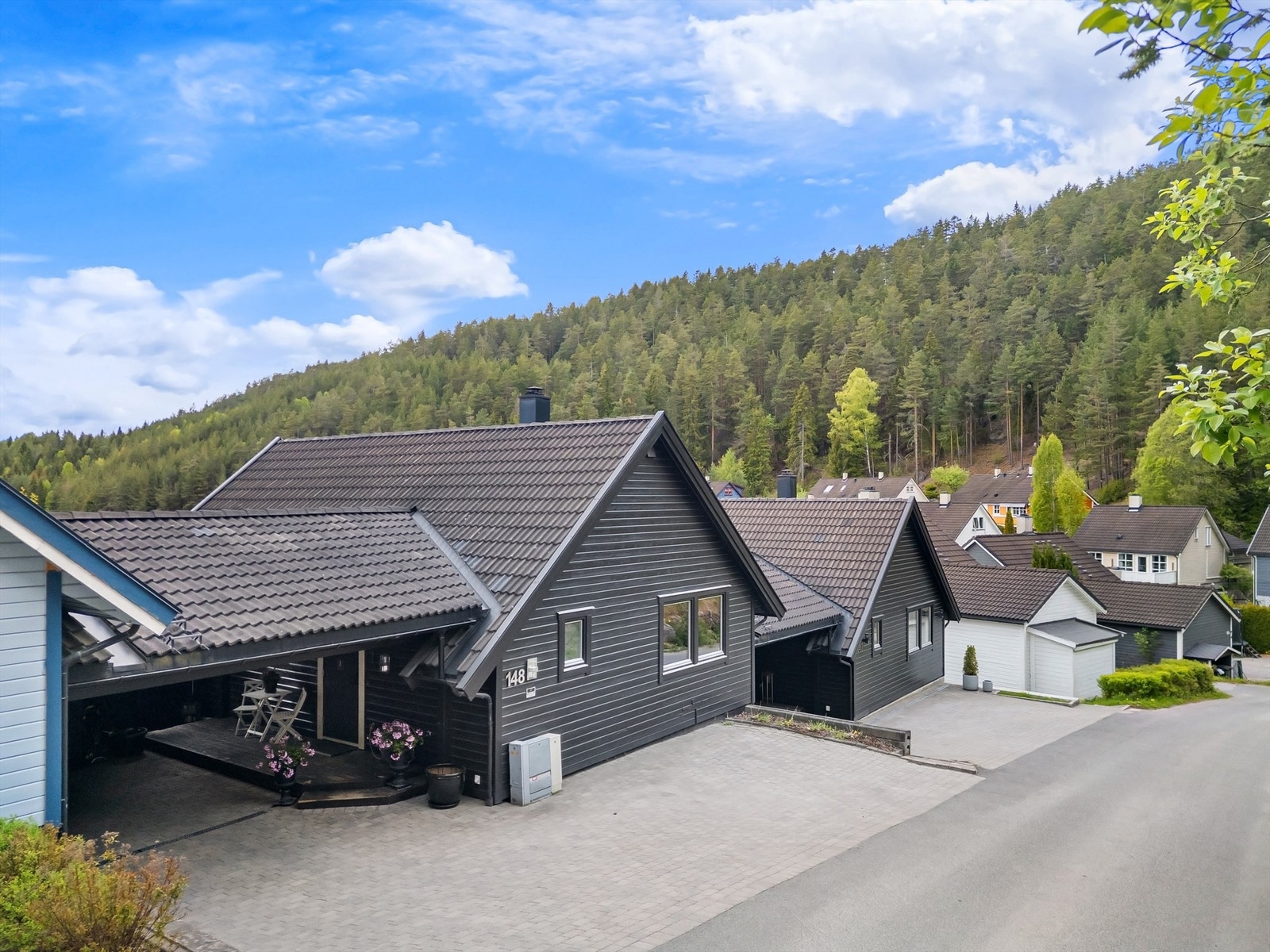 Ved inngangspartiet er det en carport på ca. 32 m² og gårdsplassen er belagt med belegningsstein. Galleribilde