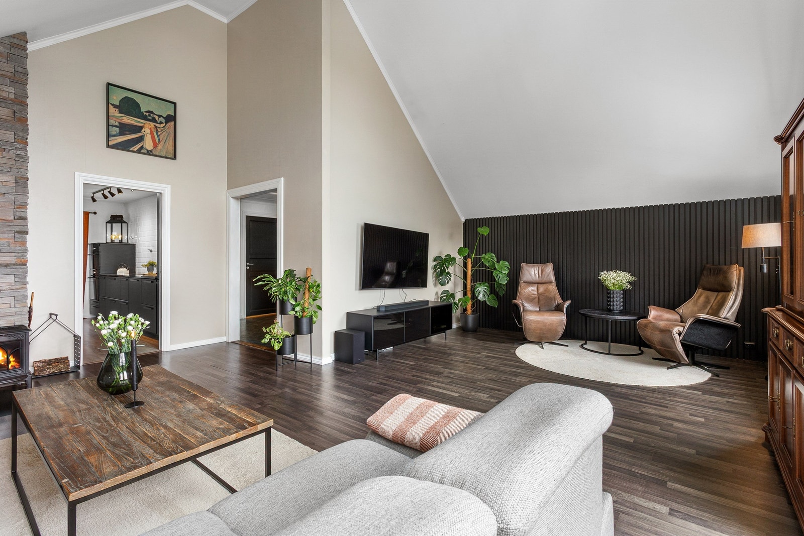 Stuen har flere soner og en moderne spilevegg som skaper en stilren overgang. Galleribilde