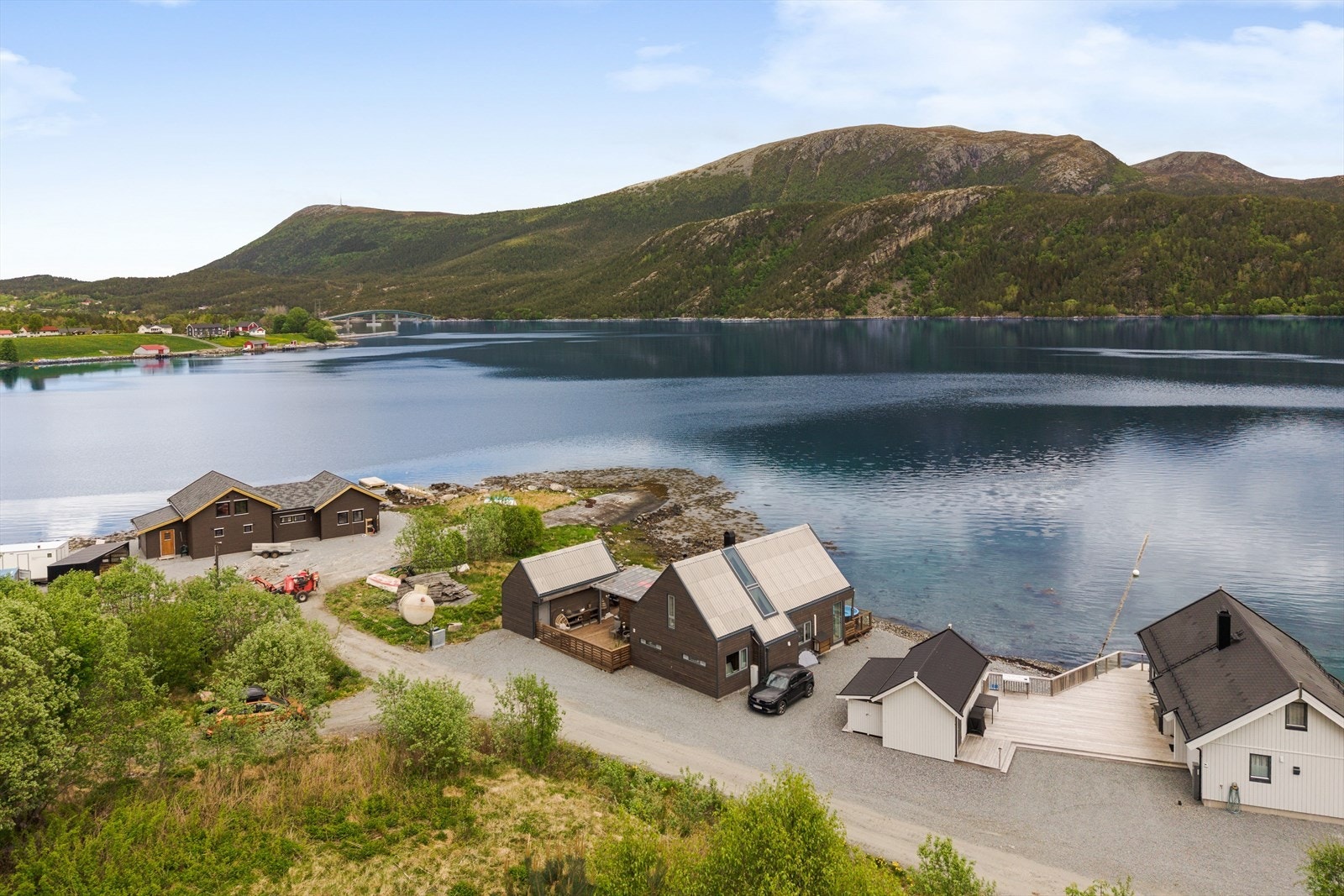 Dronebilde med hytta i midten, Dromnessundet og fjellet Fonna (et populært turmål) i bakgrunnen. Galleribilde