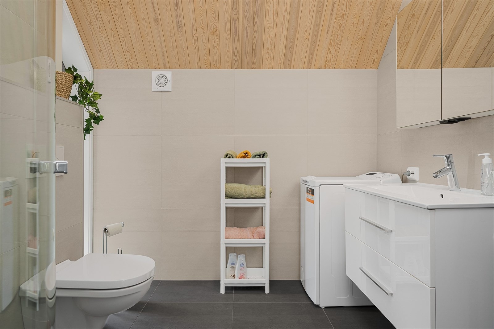 Bad med innredning, dusj-hjørne, wc og opplegg for vaskemaskin. Galleribilde