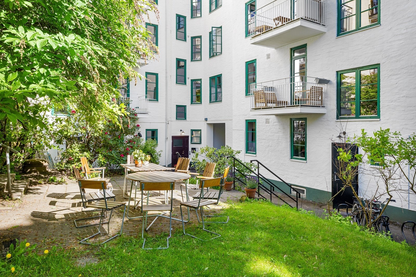 Bakgården er pent opparbeidet med plen, beplantning og steinlagte partier. Galleribilde