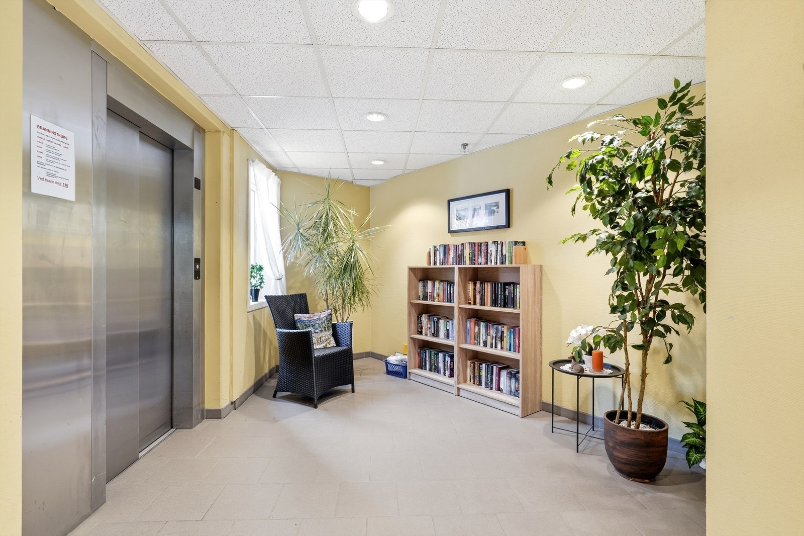 Eiendommen har et hyggelig inngangsparti, med et felles ''bibliotek'' for beboerene. Det er heis og trapper, opp til toppetasjen, hvor leiligheten ligger. Galleribilde