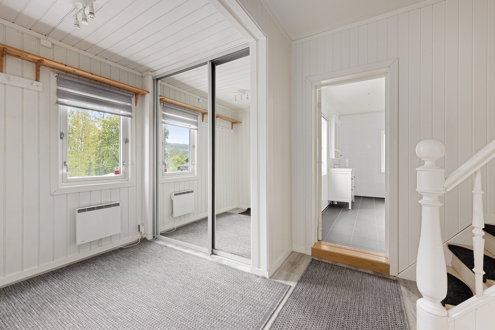 Praktisk skyvedørsgarderobe i speil for oppbevaring av yttertøy sørger for et ryddig velkommen inn. Galleribilde