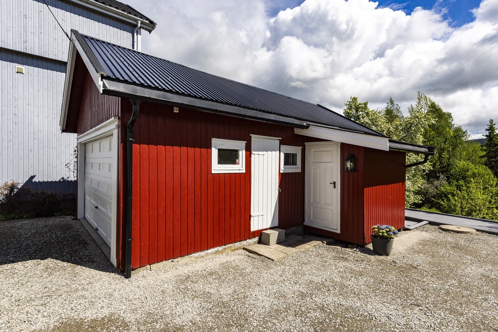 Garasjen fra 1960 er på 36 m² og inneholder både garasjerom og et separat hobbyrom. Det er innlagt strøm. Galleribilde
