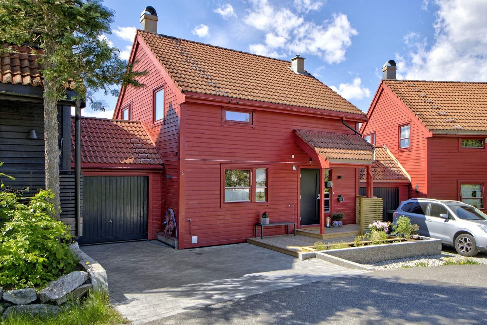 Pent opparbeidet inngangsparti med garasje (med elbil-lader) og plass til parkeringsplass på egen gårdsplass - god plass til gjesteparkering rett ved boligen Galleribilde