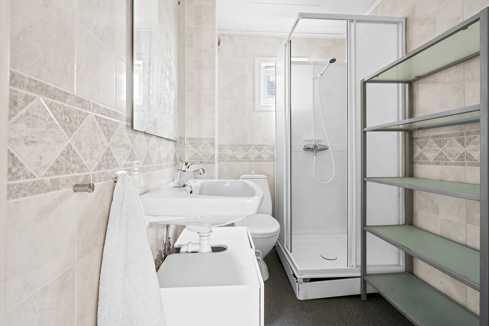 Badet i første etasje har baderomsplater på veggene, vinylbelegg på gulvet og er utstyrt med dusjkabinett. Galleribilde