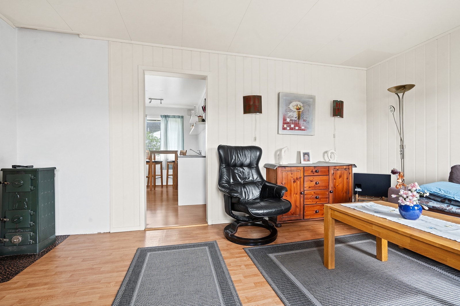En vedovn i stuen sørger for ekstra varme og hygge. Boligen har en teglsteinspipe og totalt to vedovner. Galleribilde