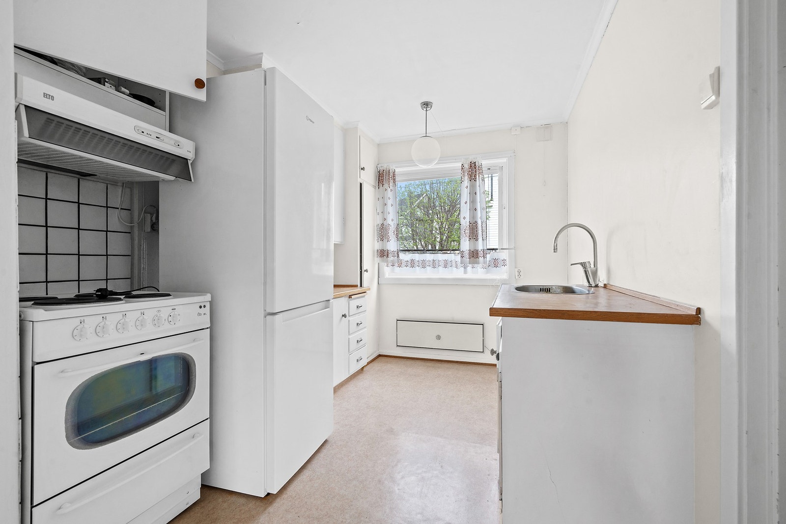 Rommet er utstyrt med frittstående kjøl-/fryseskap, komfyr og kjøkkenventilator. Galleribilde