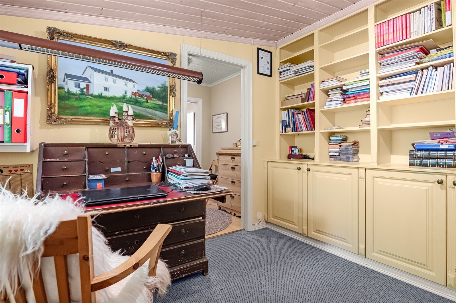 Det er plassbygde skap og bokhyller i rommet. Galleribilde