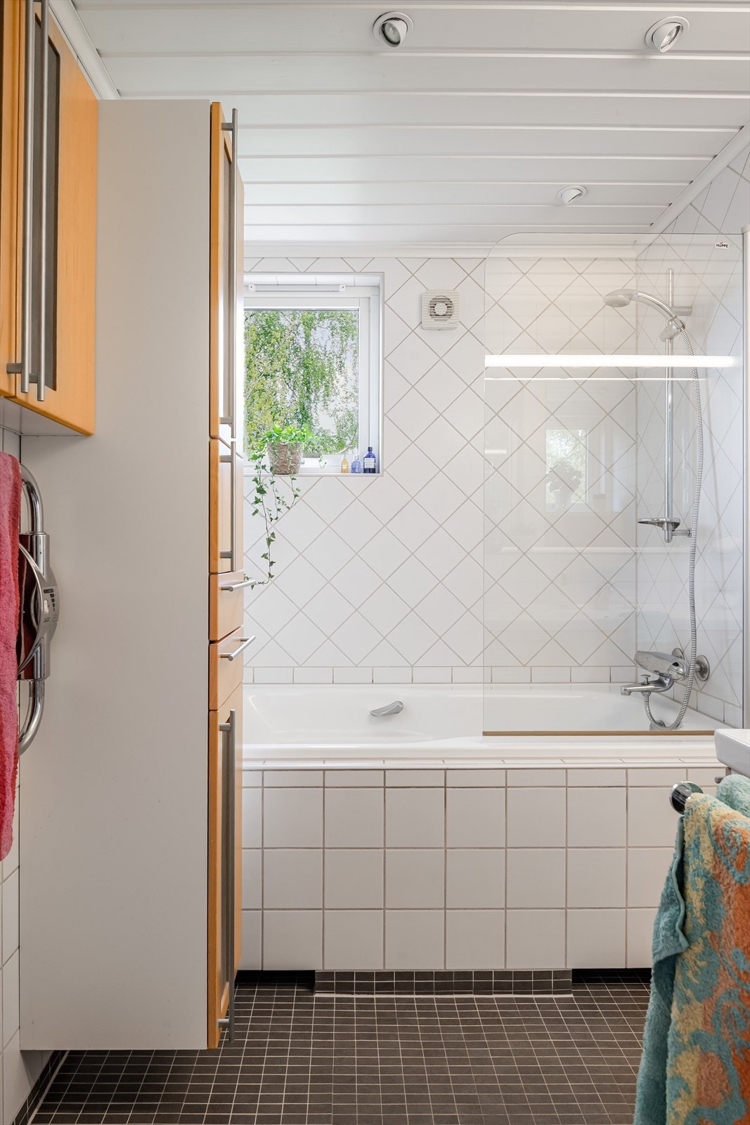 Rommet er innredet med vegghengt toalett med skjult sisterne, servantinnredning og badekar. Galleribilde