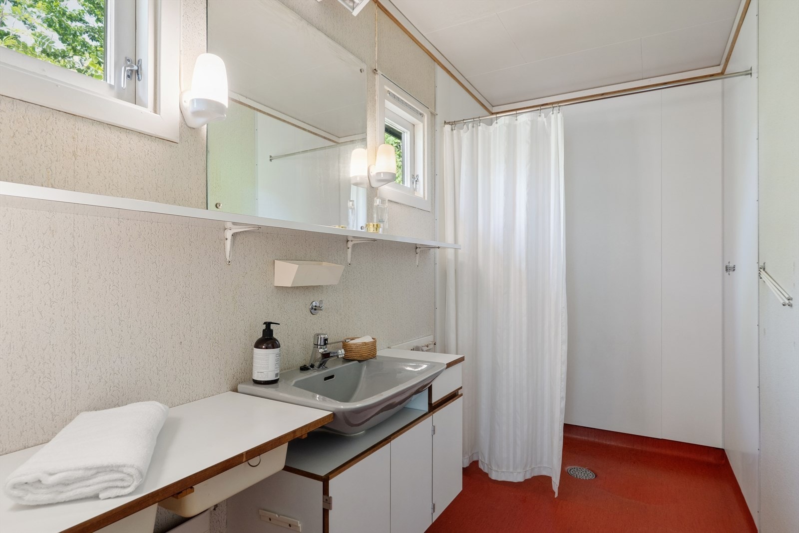 Bad i første etasje, innredet med servant og dusjnisje. Badet er fra byggeår. Galleribilde