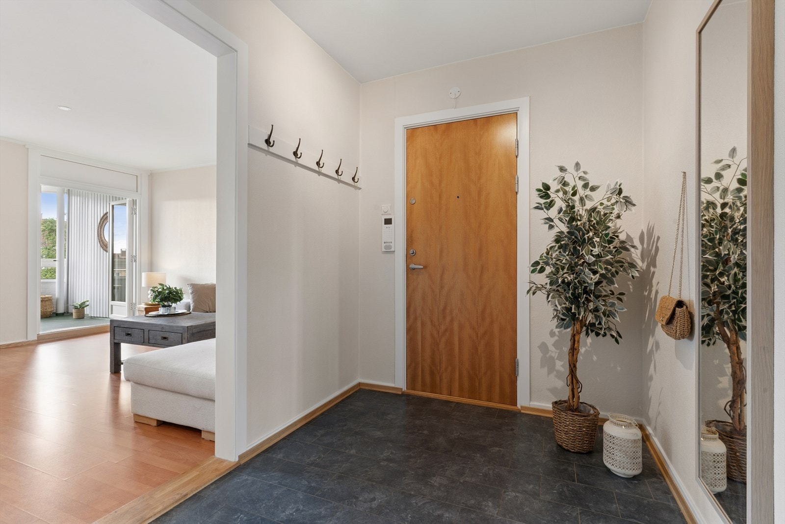 Romslig og lys entré med god plass til oppbevaring og naturlig adkomst videre inn til leilighetens oppholdsrom. Galleribilde