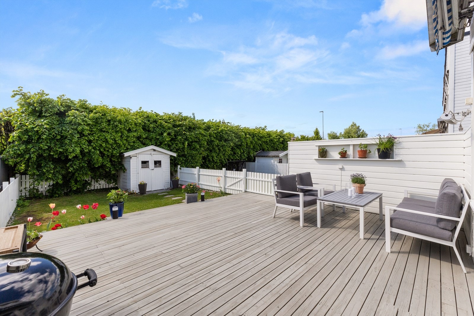Stor, solrik terrasseplatting og en liten lettstelt hage. Galleribilde