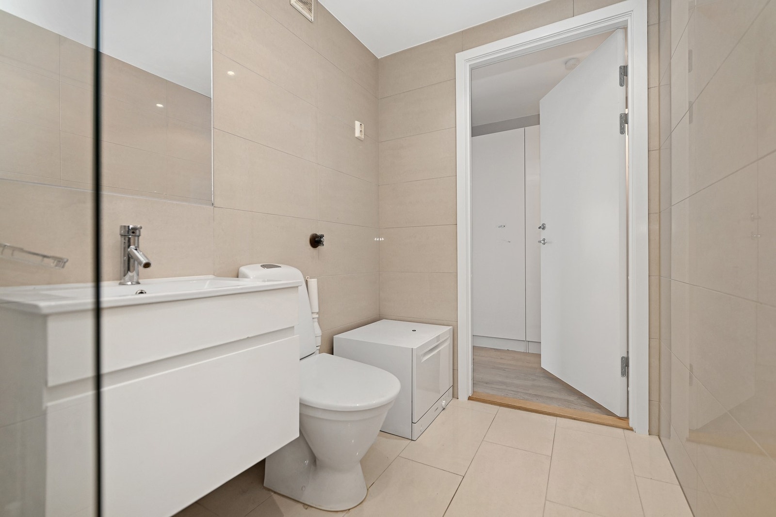 Rommet er innredet med gulvstående wc, servantskap, speil, opplegg
for vaskemaskin og dusjnisje med takdusj og hånddusj. Galleribilde