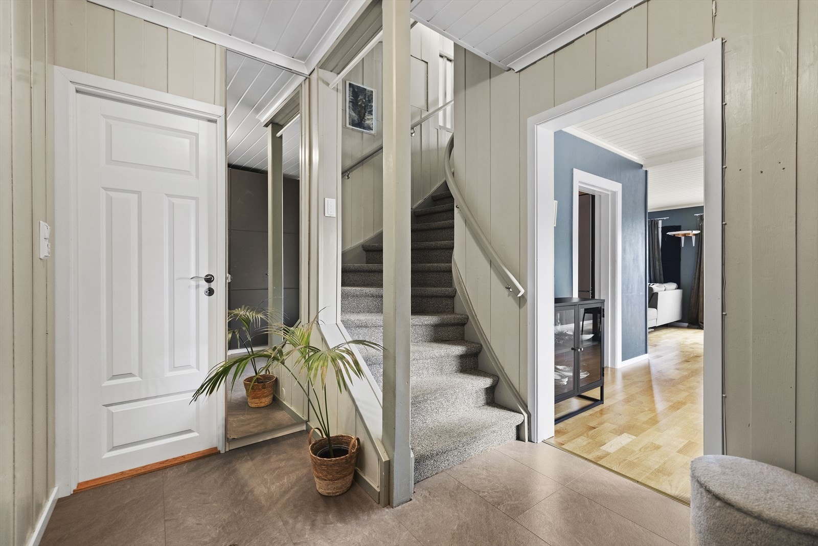 En hvitmalt tretrapp leder opp til andre etasje hvor familiens private sone ligger helt skjermet. Galleribilde