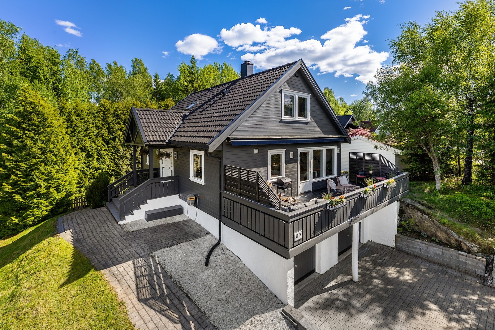 Boligen har en pent opparbeidet tomt med hage, terrasser og gode uteoppholdsarealer for hele familien. Galleribilde