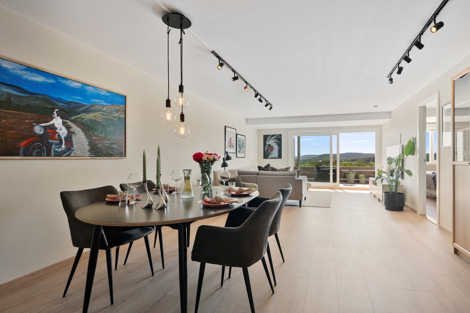 Den romslige stuen har god plass til både sofasone og spiseavdeling, med lysinnslipp fra vest og utsyn mot grønne omgivelser. Galleribilde