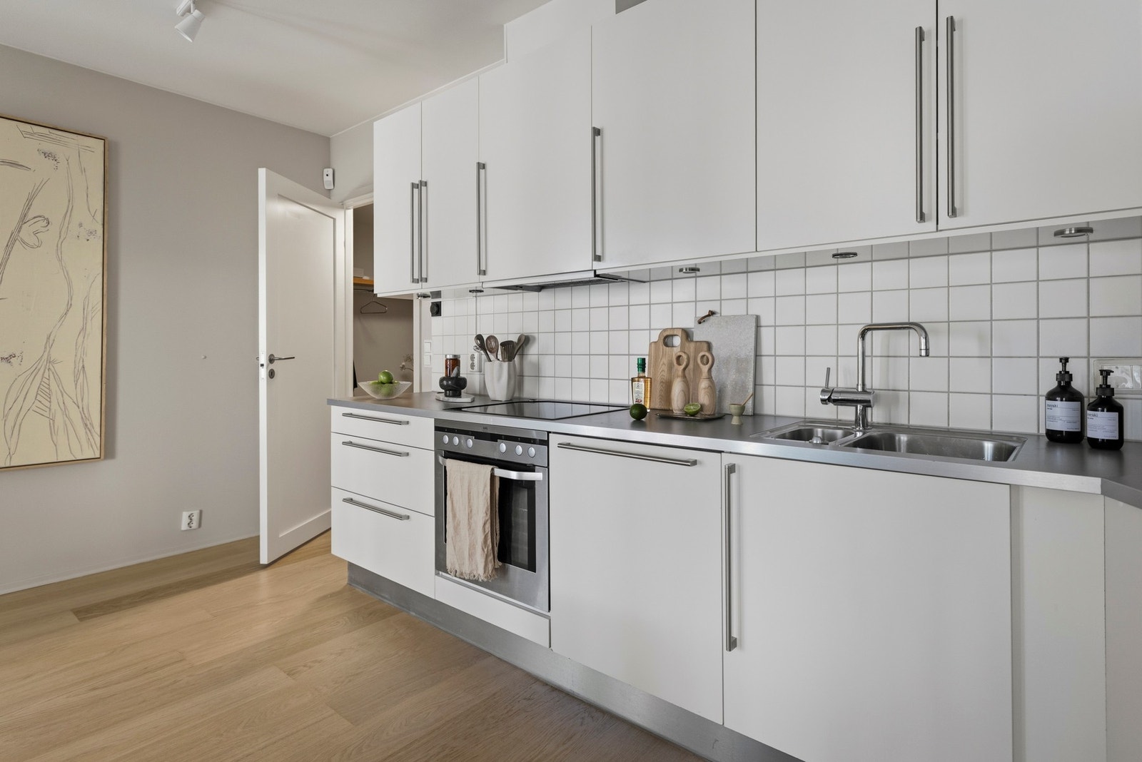 Innredningen er fra HTH og fra byggeår, med glatte, folierte fronter og laminat benkeplate med planlimt kum i rustfritt stål. Galleribilde
