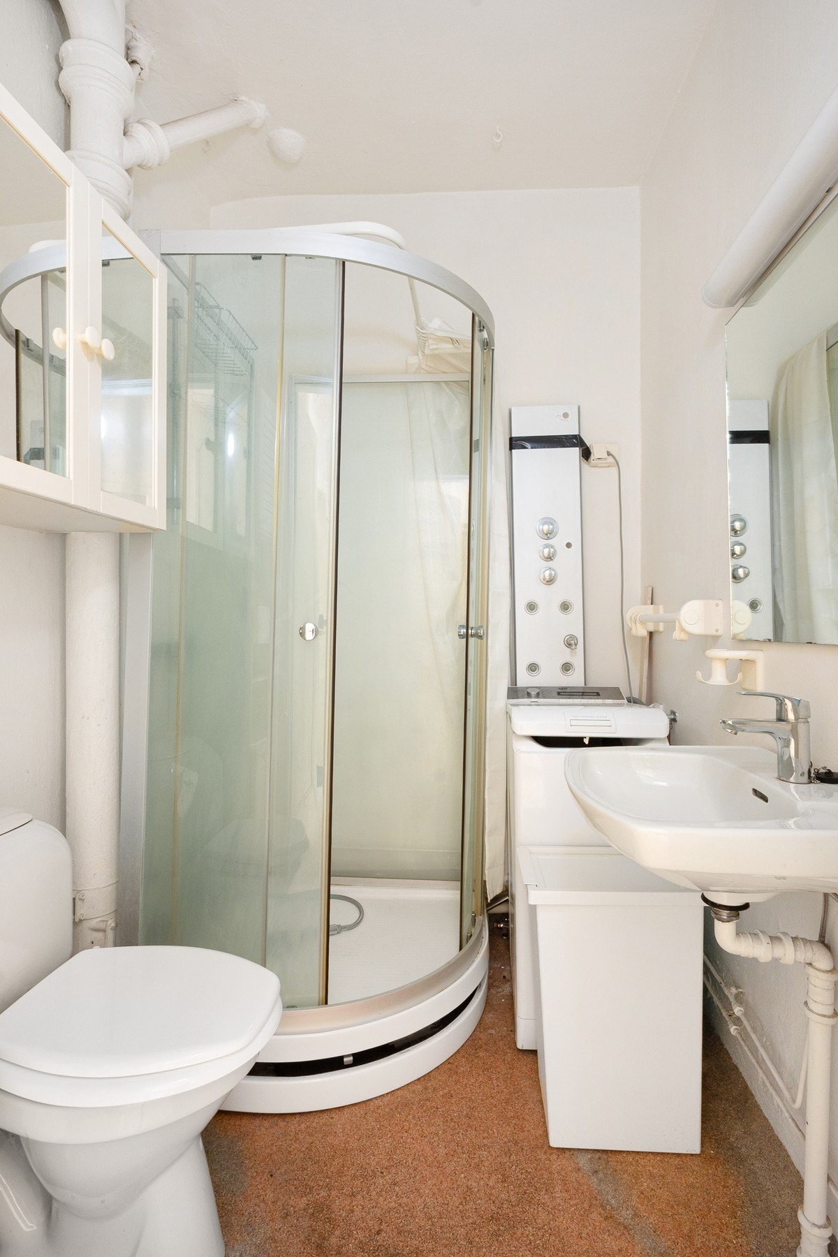 Badet er innredet med dusjkabinett, servant, gulvstående toalett og opplegg for vaskemaskin. Galleribilde