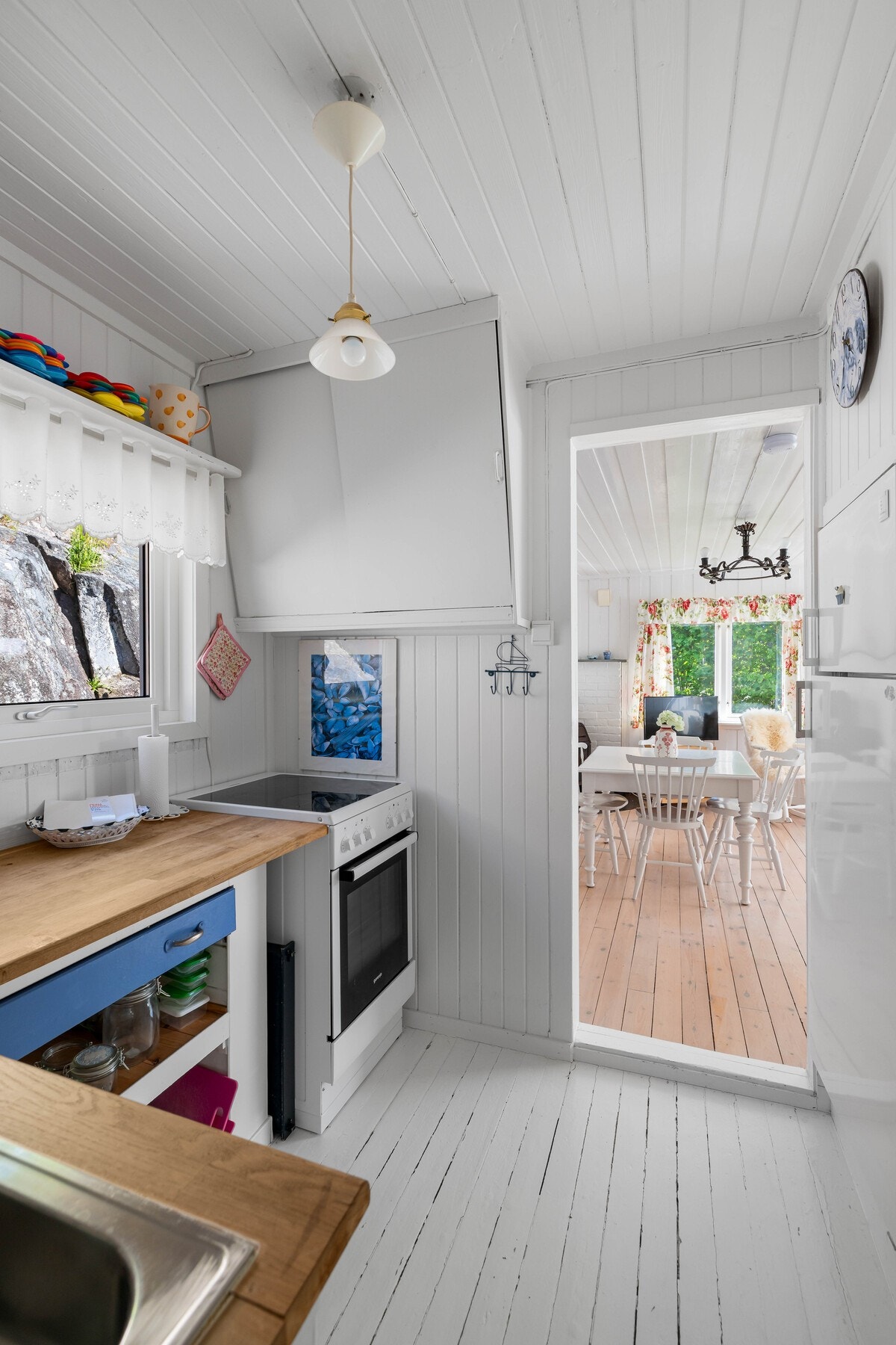 Rommet er utført med hvitmalt panel på vegger og tak, kombinert med lysmalt tregulv. Galleribilde