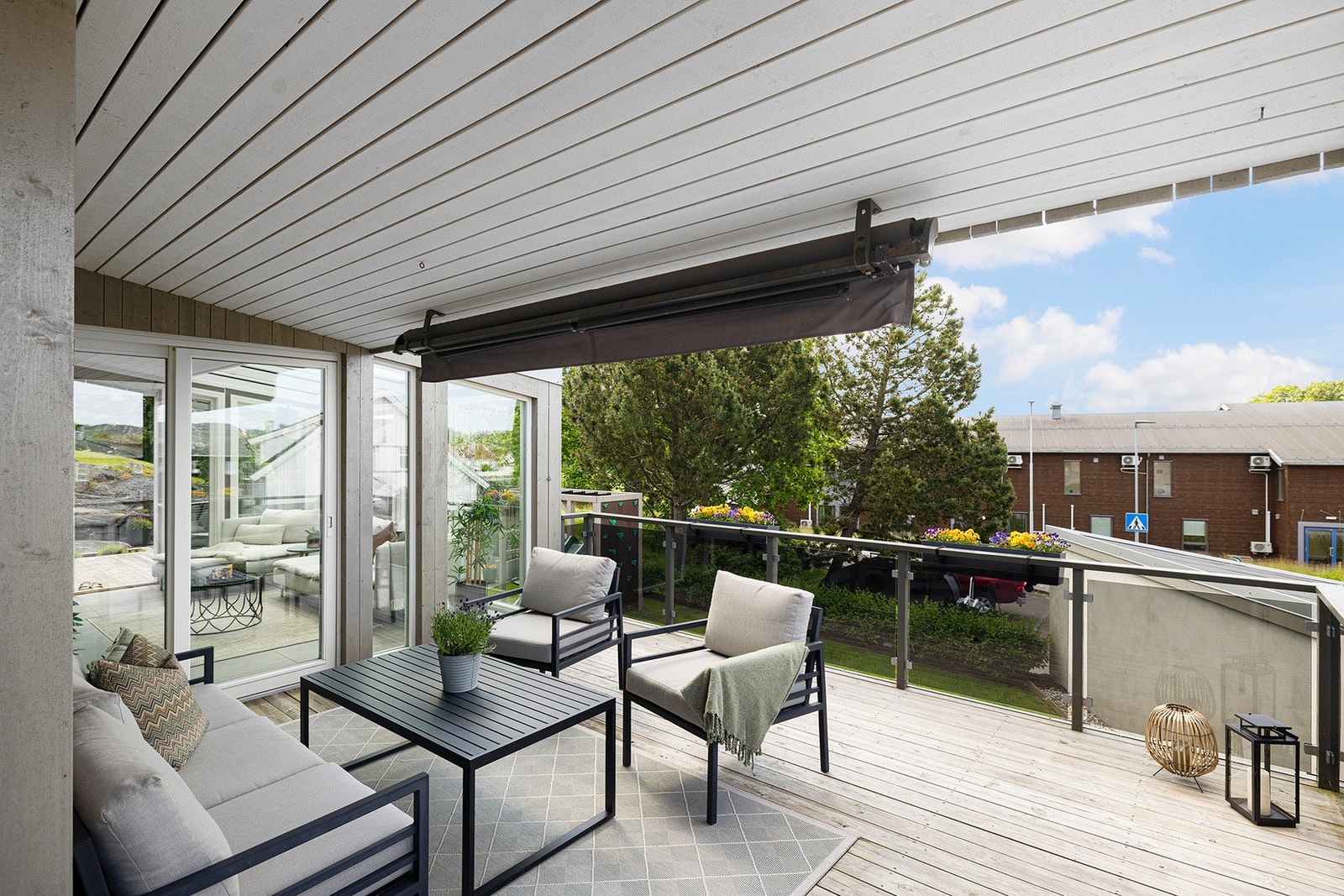 Fra stuen er det utgang til en overbygd terrasse med glassrekkverk som gir et moderne og luftig uttrykk. Galleribilde