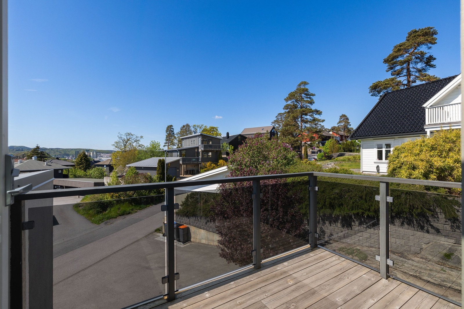 Balkong med glassrekkverk som gir utsyn over området. Galleribilde