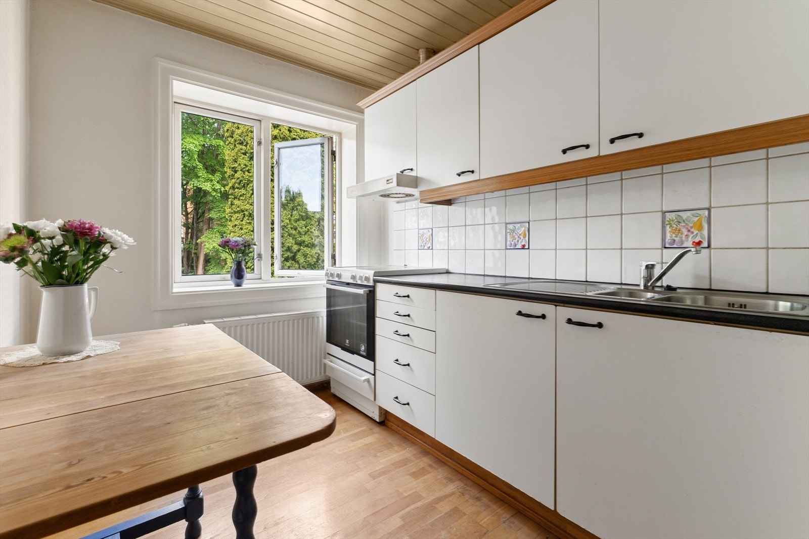 Boligens kjøkken er plassert i eget rom ved entréen og har innredning med glatte laminerte skapfronter og laminat benkeplate med fliser på bakvegg. Galleribilde