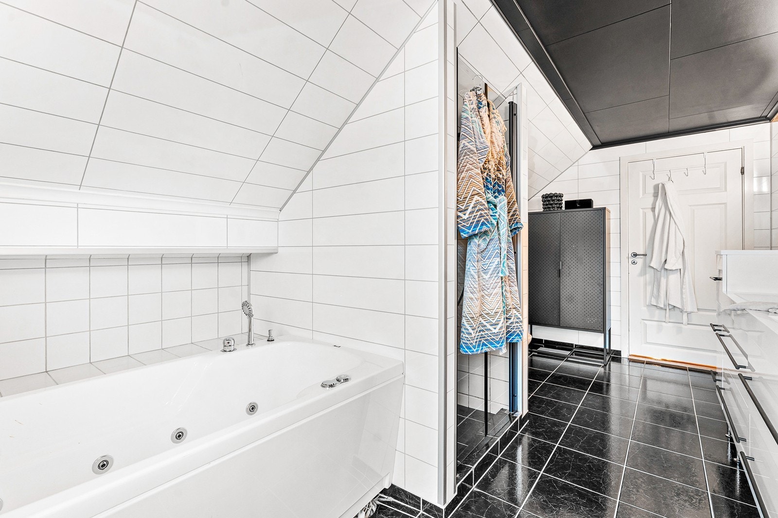 Badet fremstår lyst og praktisk med gulvfliser og behagelige varmekabler. Galleribilde