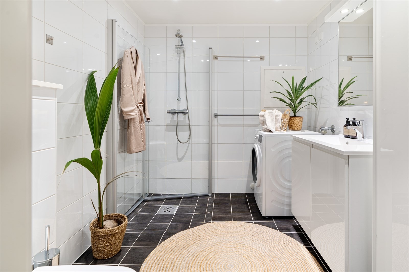 Det flislagte badet er praktisk innredet med dusjhjørne, servant og toalett. Galleribilde