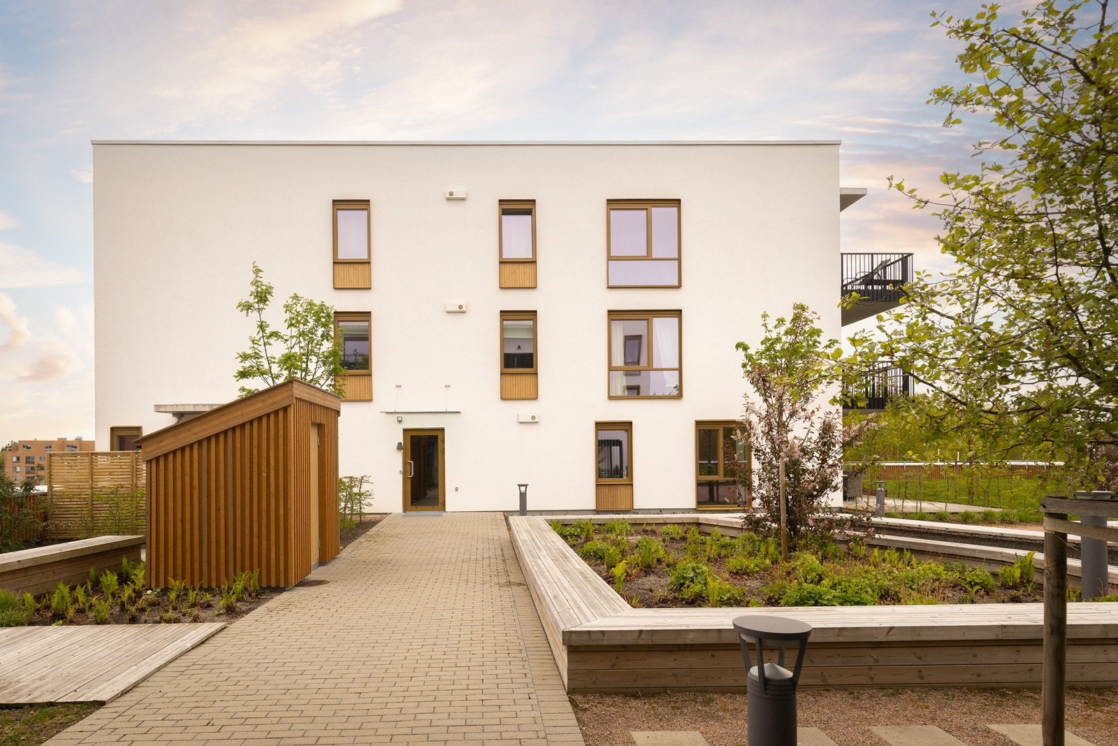 Pent opparbeidede fellesarealer med sittegrupper, beplantning og gangstier. Galleribilde